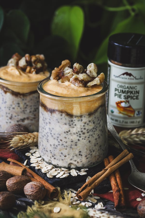 A jar of pumpkin spice overnight oats topped with walnuts is ready to be eaten