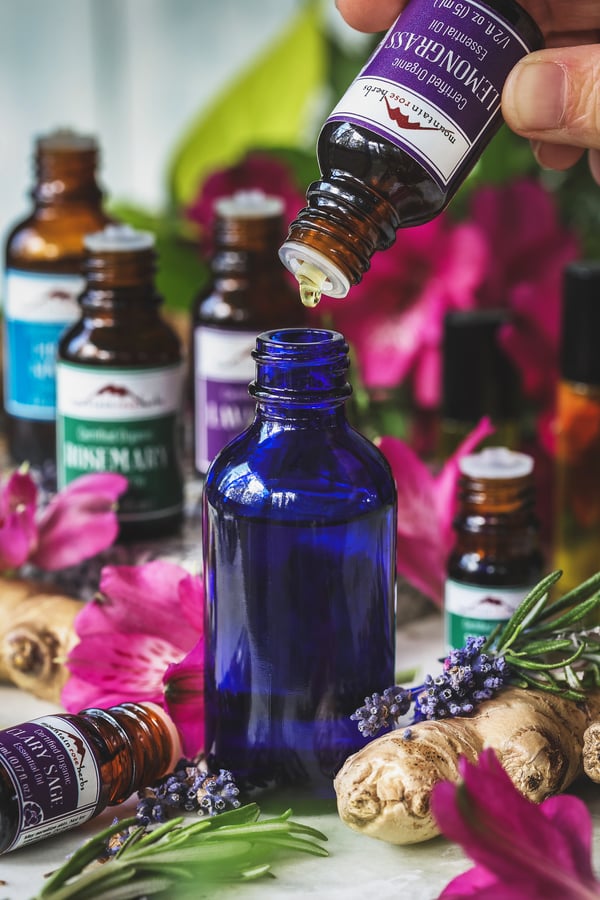 Lemongrass essential oil being dripped into small bottle for blending