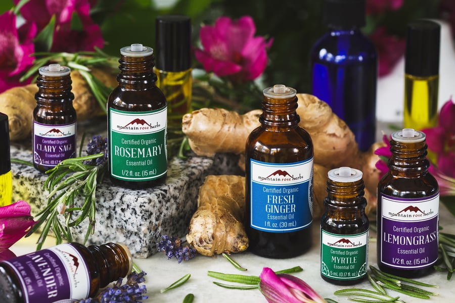 A selection of essential oils used in spring essential blend with ingredients around them