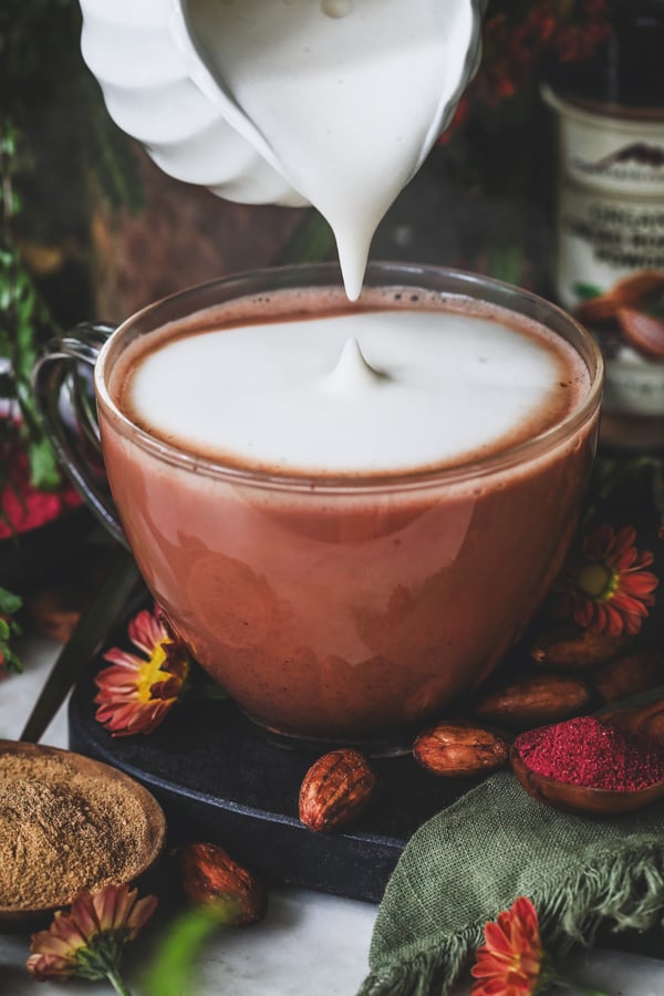 Foamed milk gets poured onto top of red velvet latte