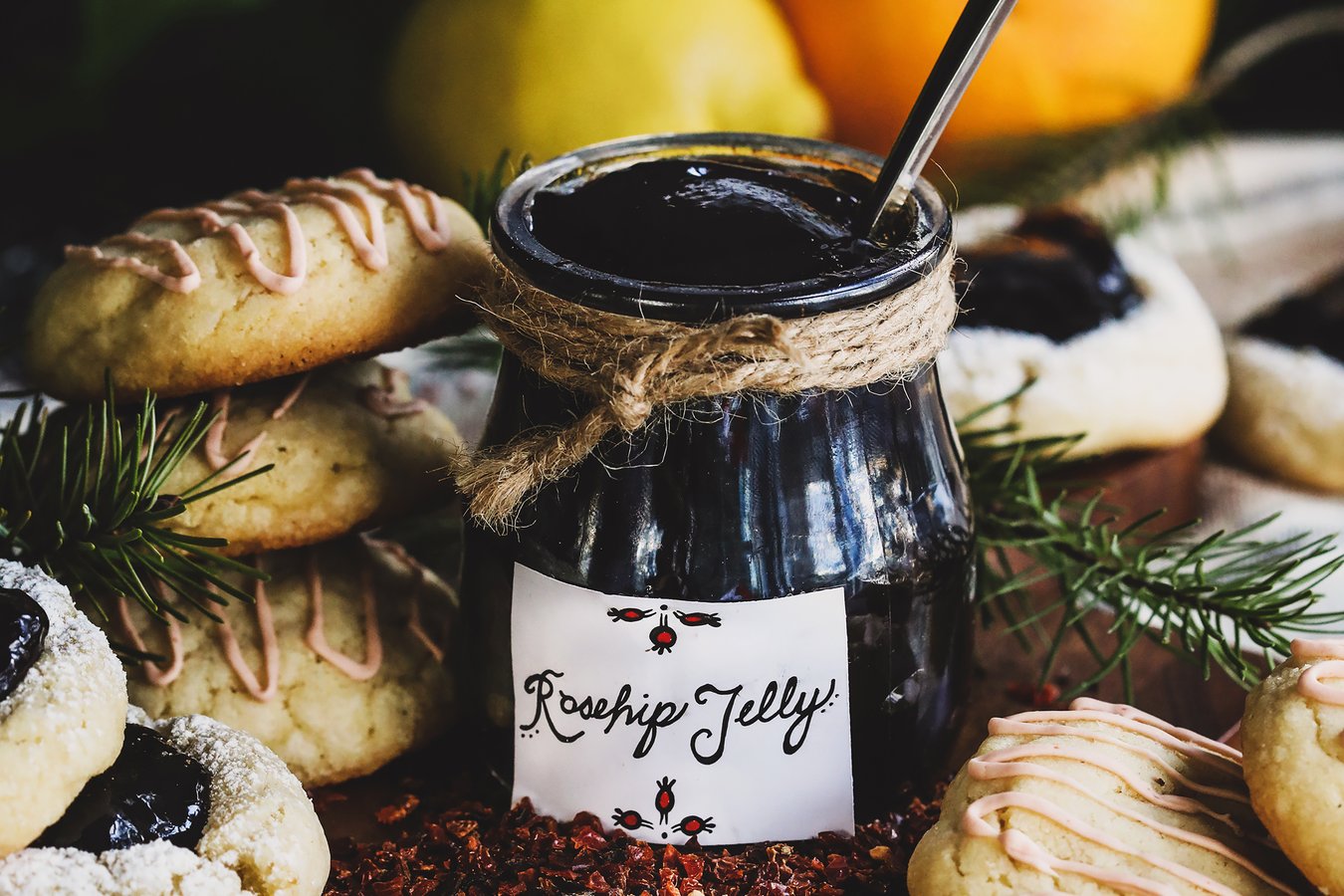 Rosehip Jelly Jar surrounded by fresh baked cookies. 