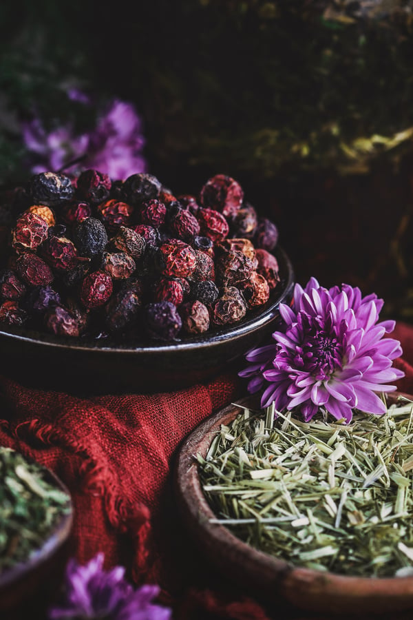 Close up shot of dried hawthorn berries with oatstraw nearby