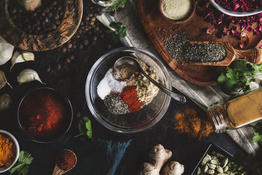 A variety of herbs and spices lay out on a work station 