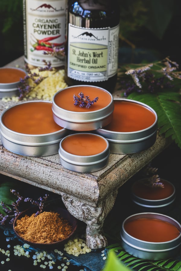 St johns wort salve sits amongst cayenne and beeswax pastilles