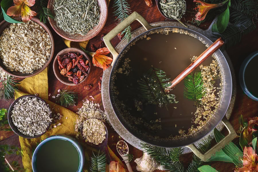 An overhead photo of a pot with dried ginger root and pine needles