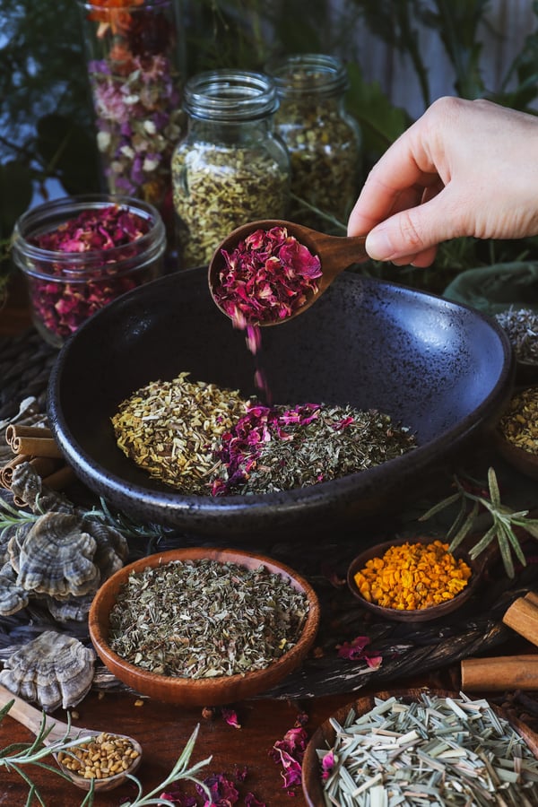 A photo of dried herbs being blended into a tea
