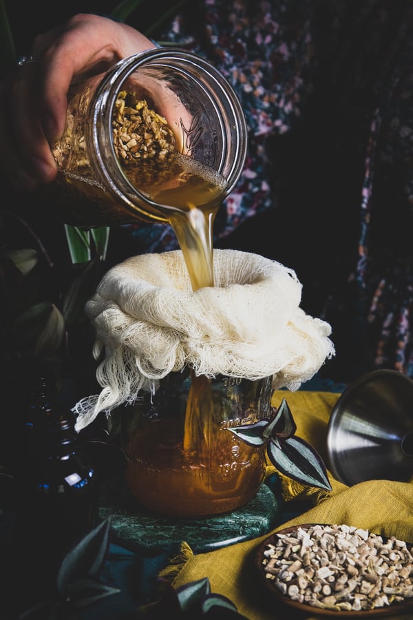 An ashwagandha extract being strained through a cheesecloth