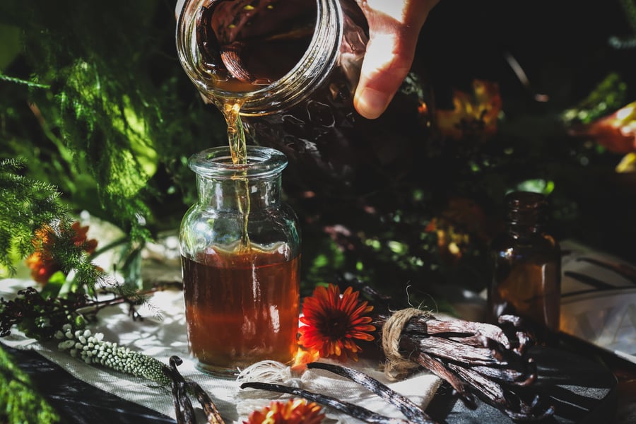 Homemade vanilla extract is poured from into smaller jar for easy use