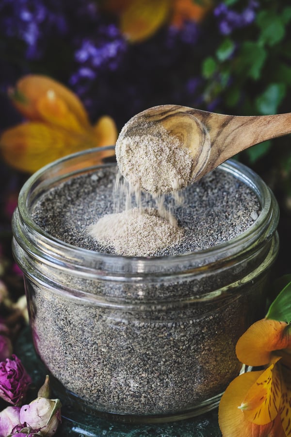 Incense powder being sprinkled onto a jar full of sand