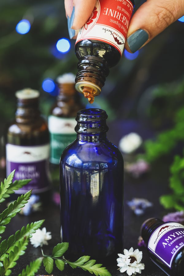 Tangerine essential oil is being dropped into 2oz mister bottle