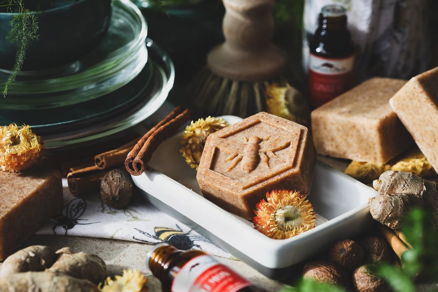 A dish soap bar sits in a soap dish with ingredients around it