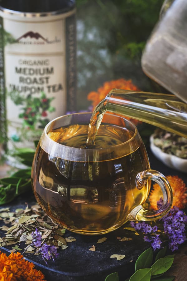 Brewed yaupon being poured into a glass mug