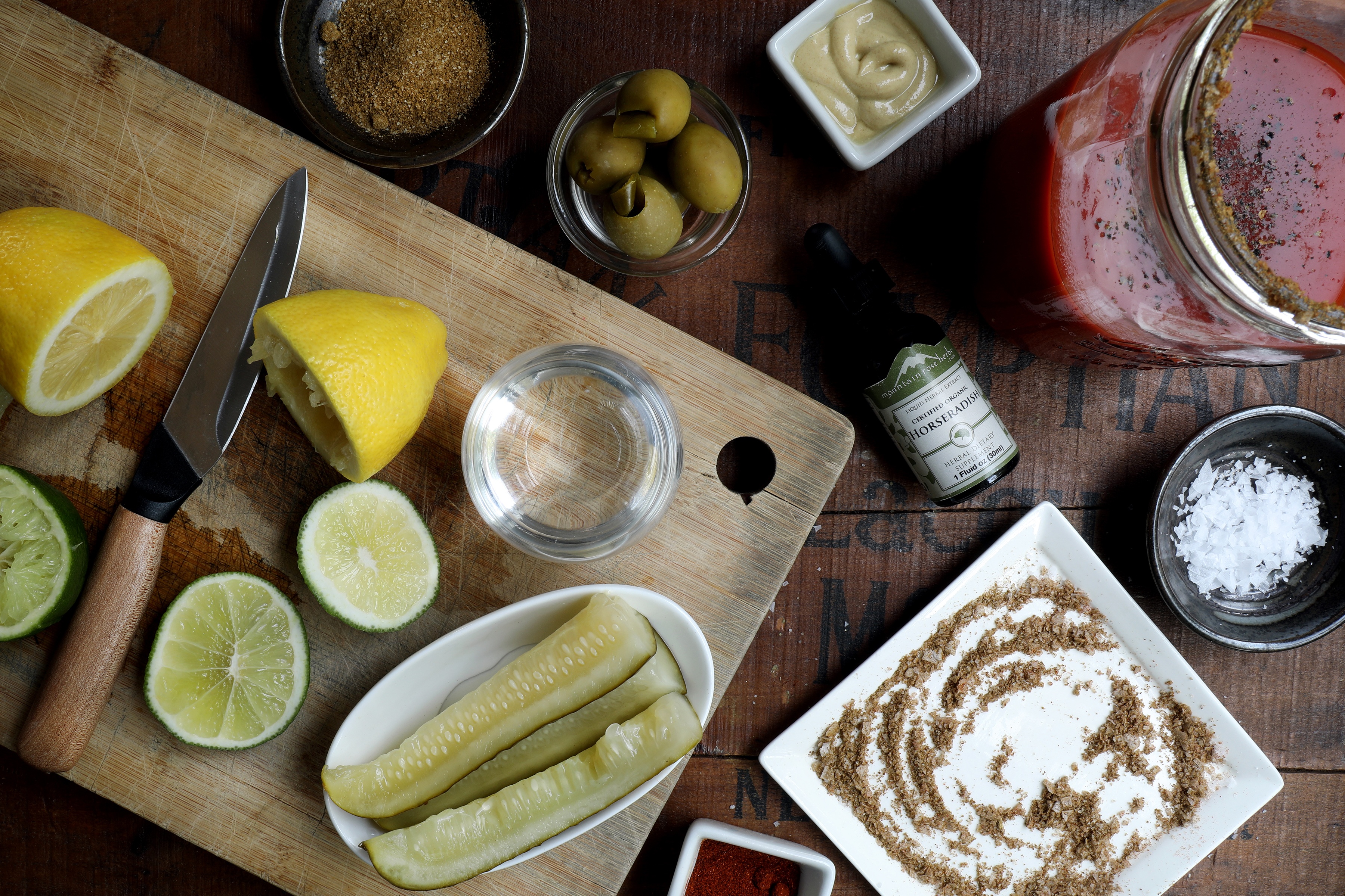 rd with Bloody Mary fixings like cut citrus, bowl of olives, pickles and culinary saltsCutting boa