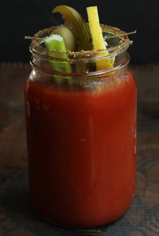 Mason Jar of Bloody Mary with Celery Olive Pickle and Lemon Garnishing