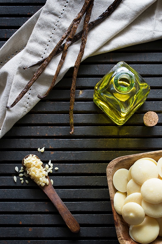 Organic lip balm ingredients beeswax, vanilla beans, oil in glass bottle