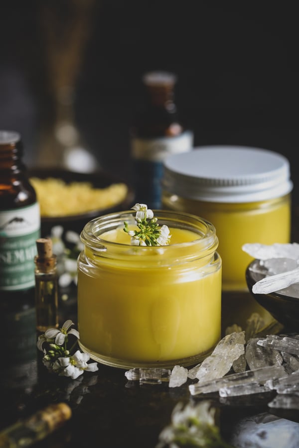 Jars of menthol rub with eucalyptus essential oil, surrounded by menthol crystals