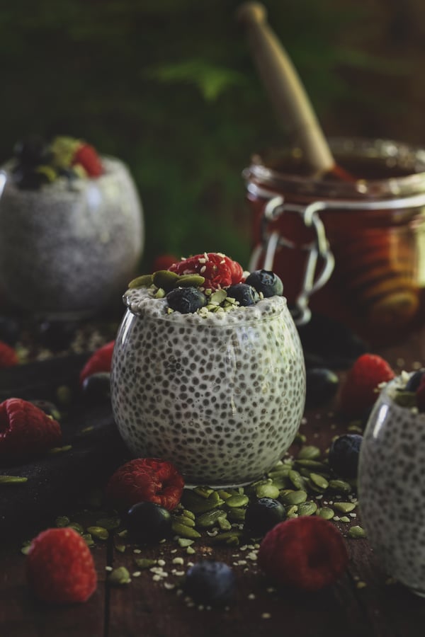 Glass cup with colorful chia putting and fresh berries. 