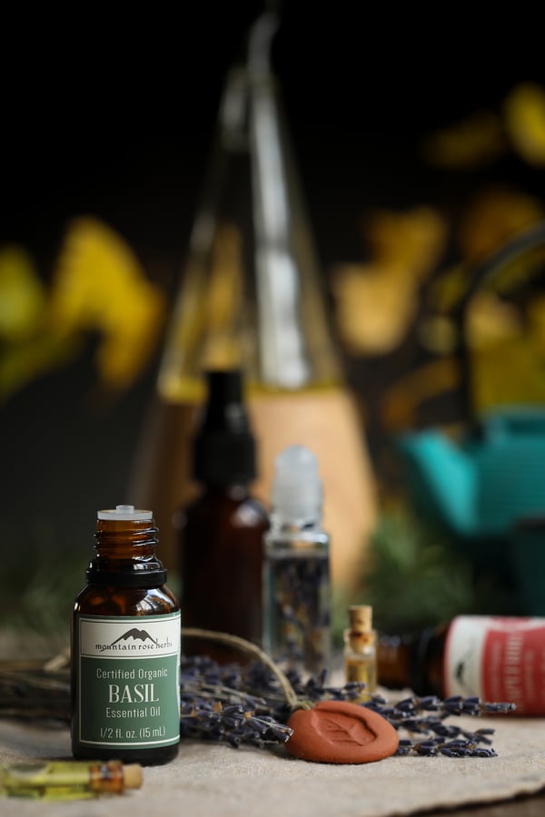 Basil essential oil in front of a diffuser and a scent stone