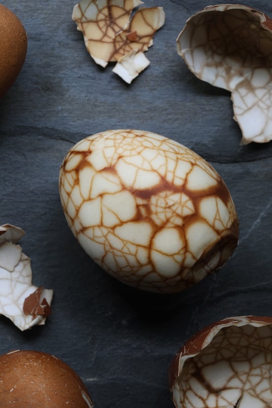Close up photo of marbled tea egg showing brown lines along cracked area