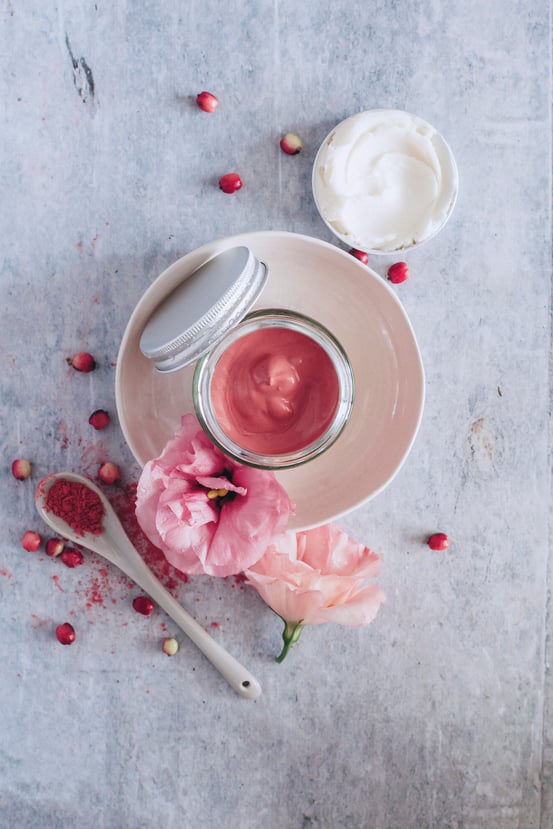 Jar of cranberry cheek and lip stain with flowers and wooden spoon