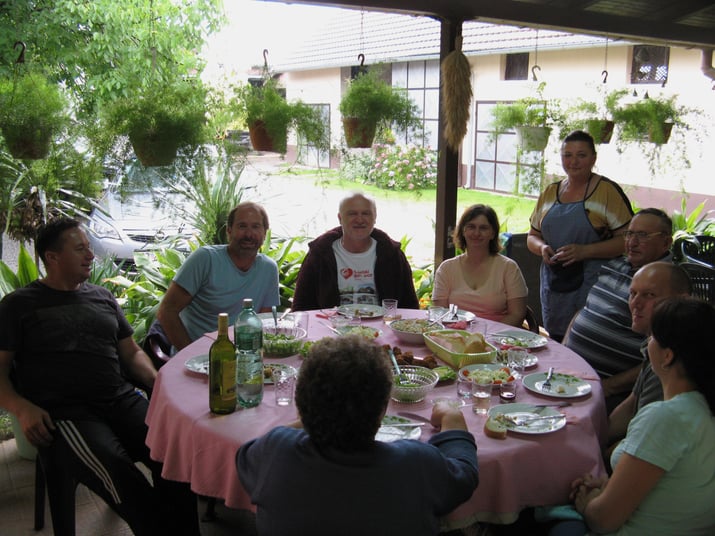 Group of people sitting around a dining table in Croatia enjoying a family farm-to-table dinner