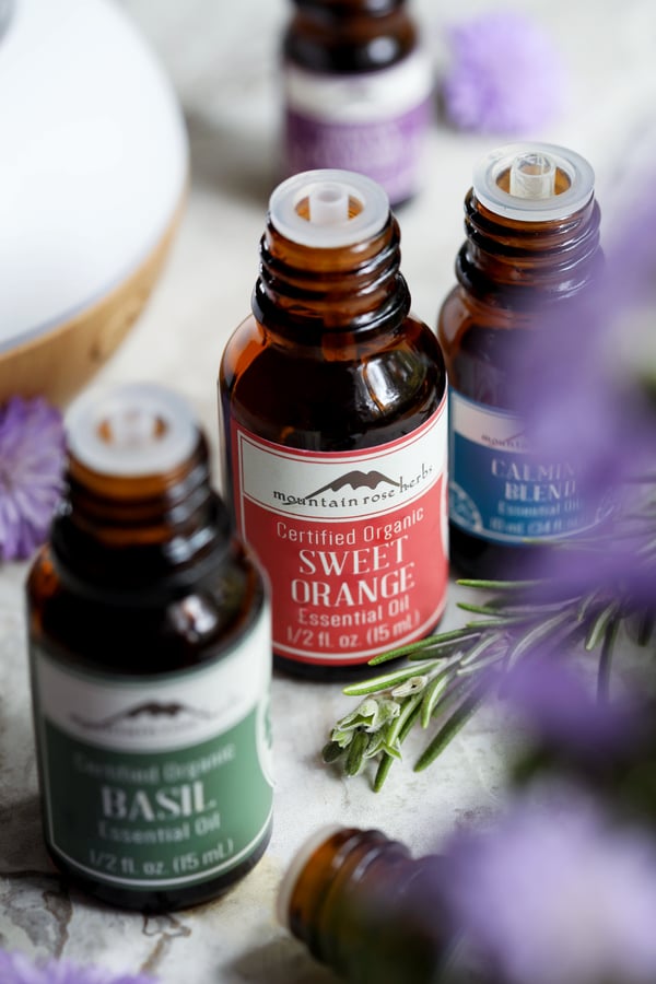 Bottles of Mountain Rose Herbs' essential oils that can be supportive with stress management, including basil, sweet orange, and calming blend.