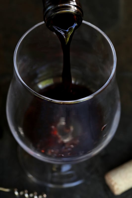 Pouring red berry mead into glass