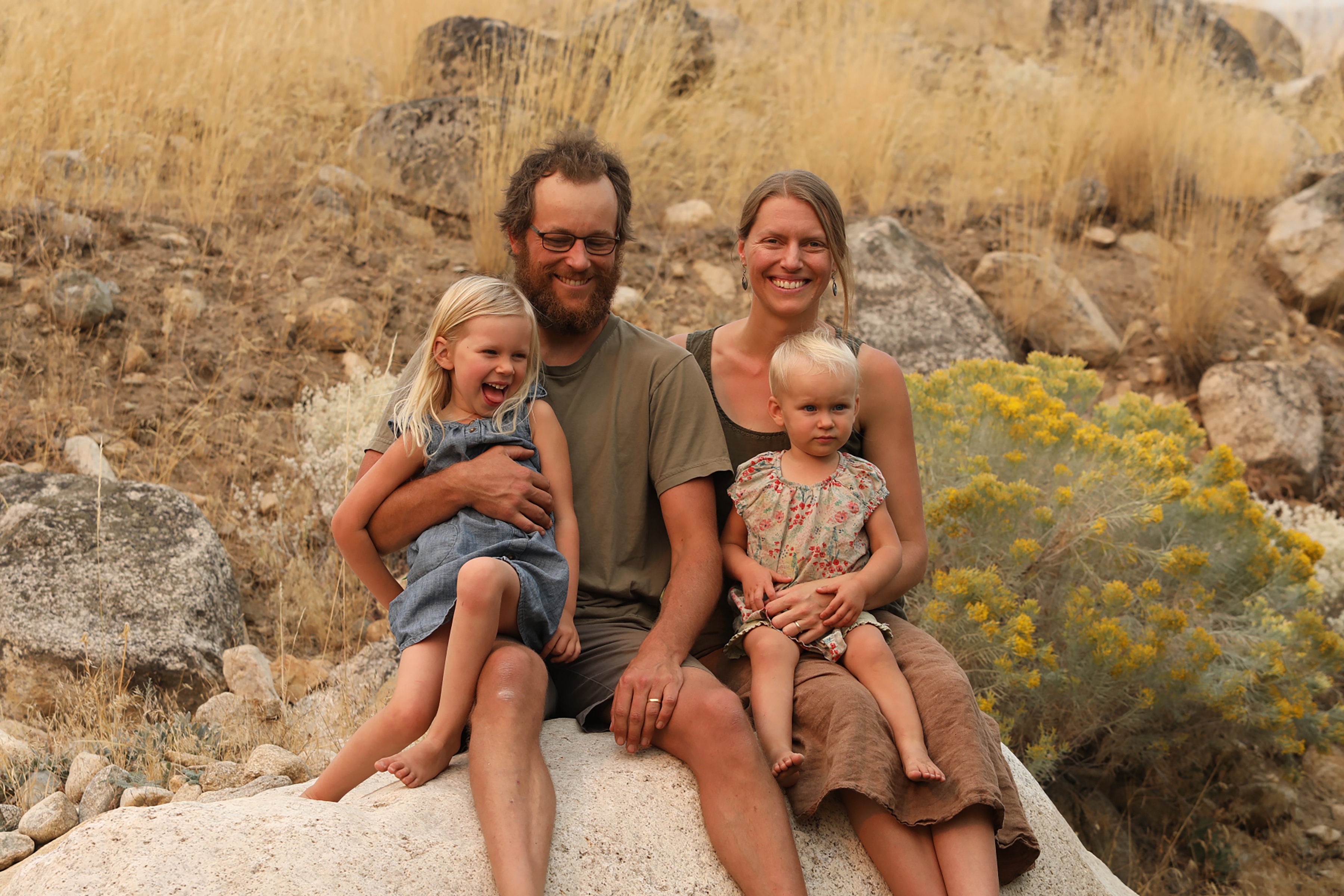 Young family of four sitting on a rock in the Washington mountains