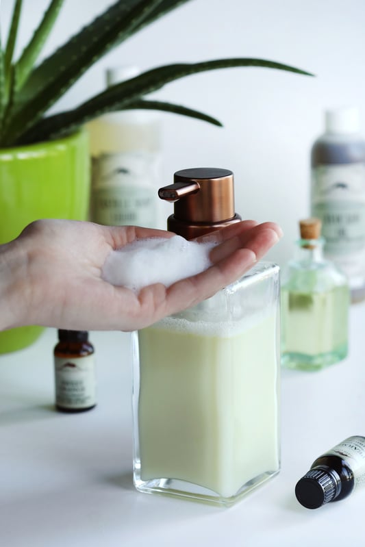 Natural foaming hand soap dispensed from a foaming soap hand pump dispenser is made from blending organic essential oils, avocado oil, and natural castille liquid soap. 