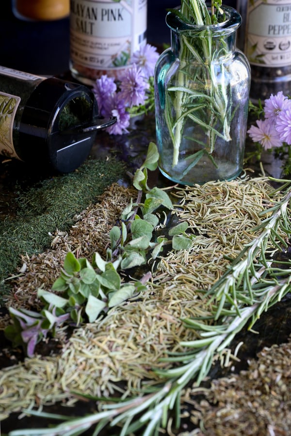 Fresh and dried herbs laid out on a table.
