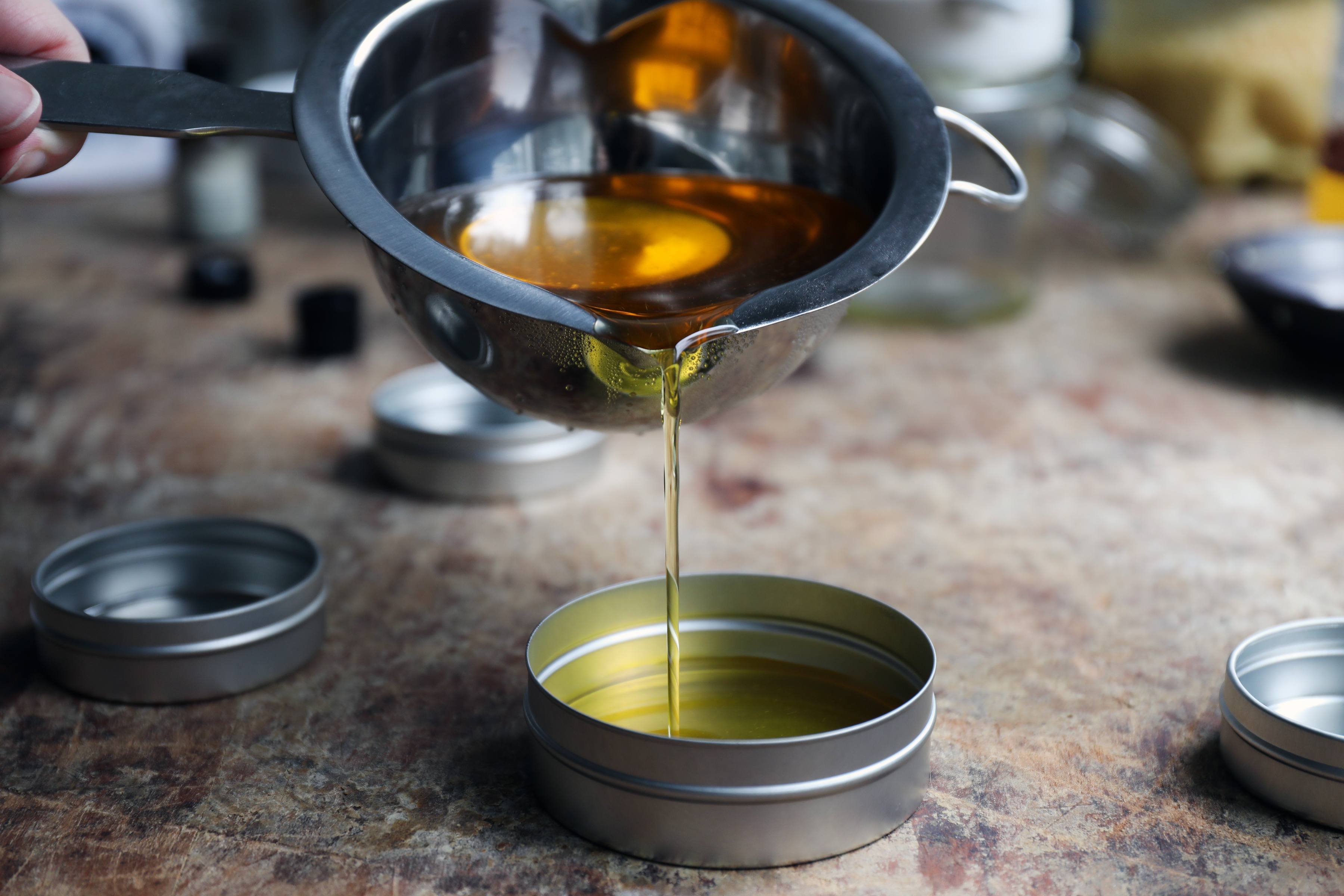 Pouring salve solution into tins. 