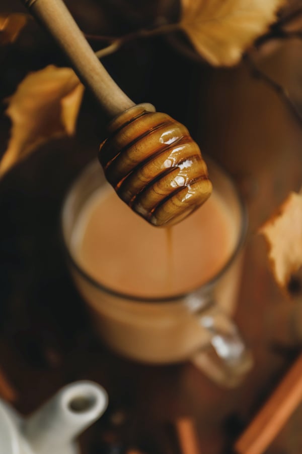 Honey dispenser dripping honey into Gaurana seed hot drink 