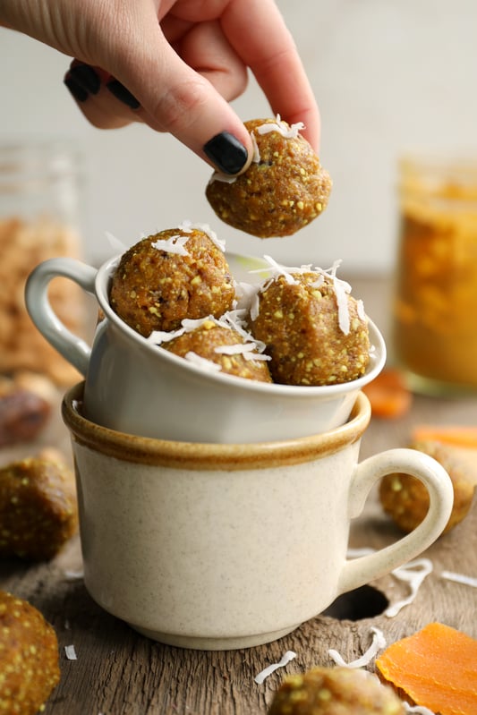 Snacking on golden milk energy balls in tea cup.