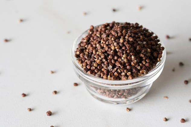 grains of paradise in a glass bowl on a white counter