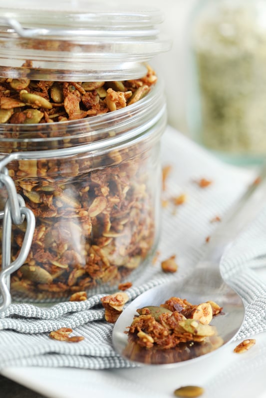 Pantry jar full of homemade granola featuring pumpkin seeds, hemp seeds, almonds, and coconut. Fresh and healthy homemade granola recipe for on the go snacking. 