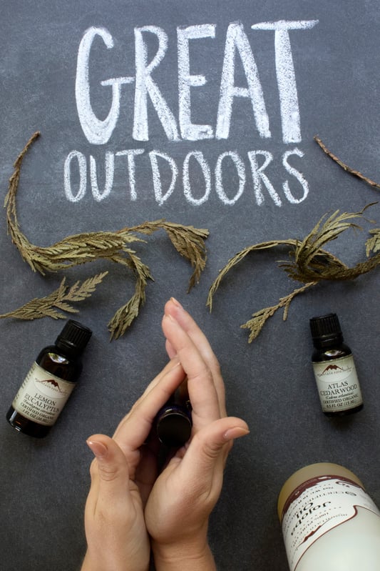 Hands rubbing oils together in glass bottle Great Outdoors essential oil fragrance recipe