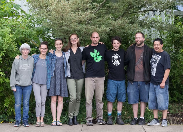 Employees at Mountain Rose Herbs meet for a Green Team meeting, standing together outdoors