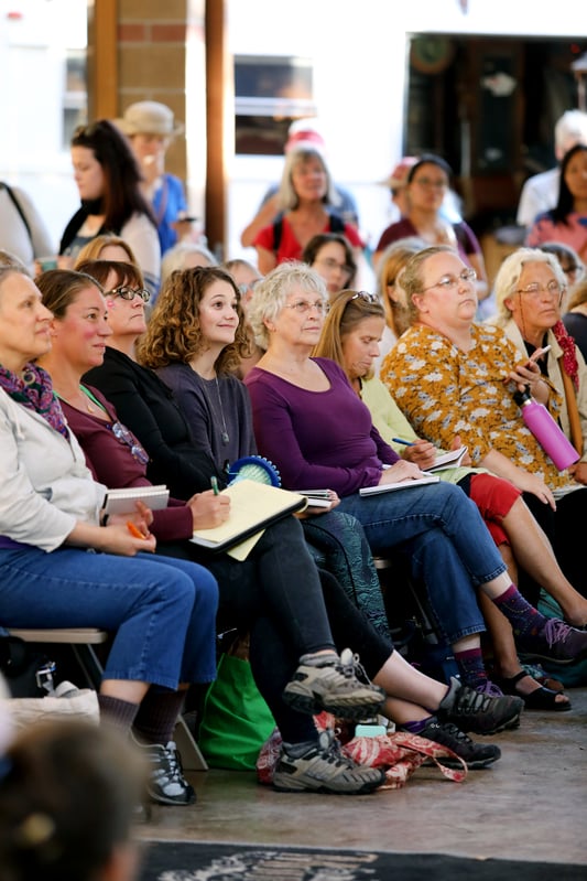 Group of people in varying age listening to a talk at the Mountain Rose Herbs Free Herbalism Project. 