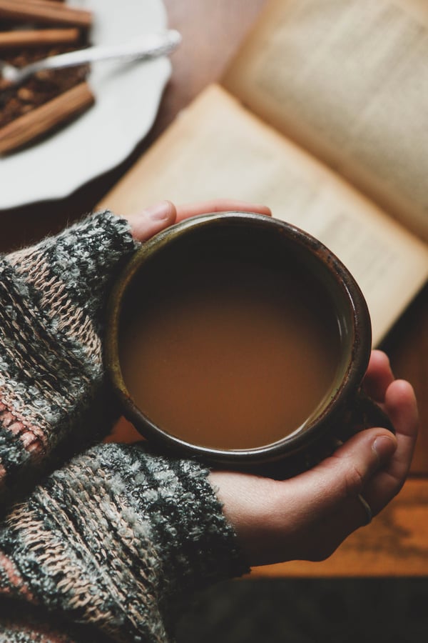 hands hold mug with warm beverage