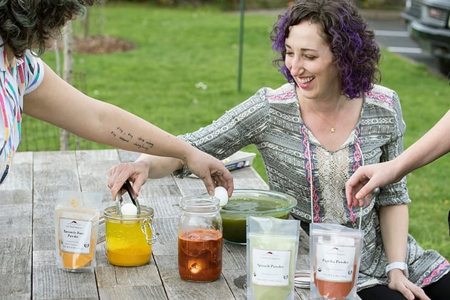 Ladies coloring eggs with herbal ingredients 