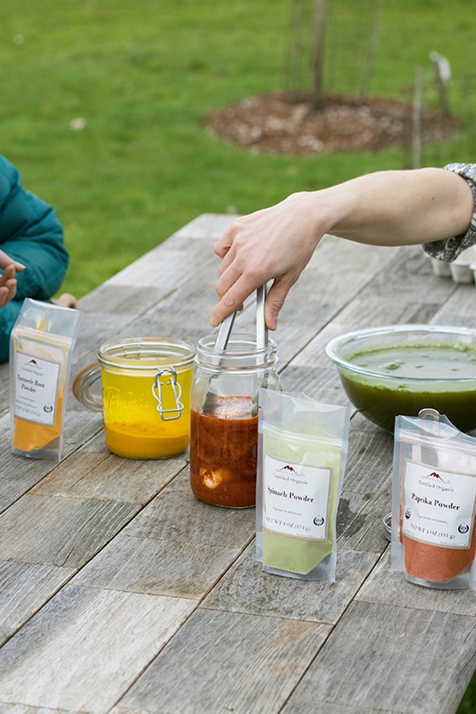 Hand scooping egg from herbal dye water