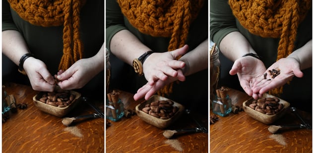 Hands rubbing and crushing whole cacao beans