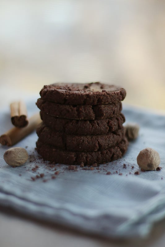 A stack of chocolate de mesa discs with Ceylon cinnamon, or true cinnamon, and whole nutmeg. Chocolate de mesa discs are used to make traditional Mexican hot chocolate beverages.