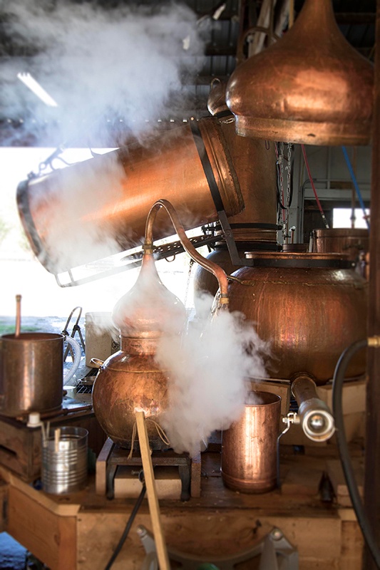 Copper stills with steam coming out of them