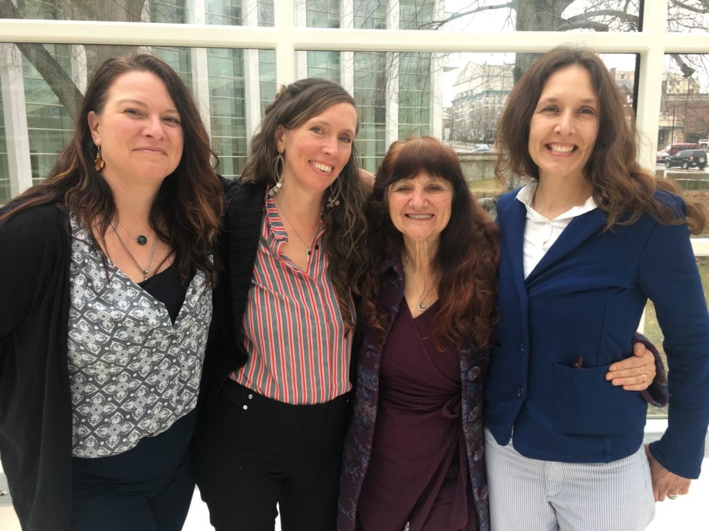 Rosemary Gladstar, Nicole Telkes, Kathi Langelier, and Mary Blue huddle together after trials over trademark of Fire Cider took place in Springfield, Massachusetts. 