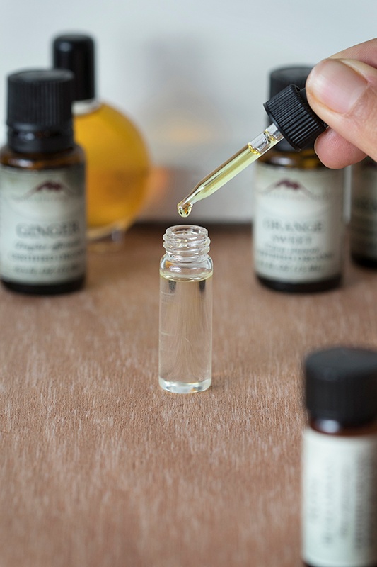 Essential Oils Being Dropped Into Glass Bottle
