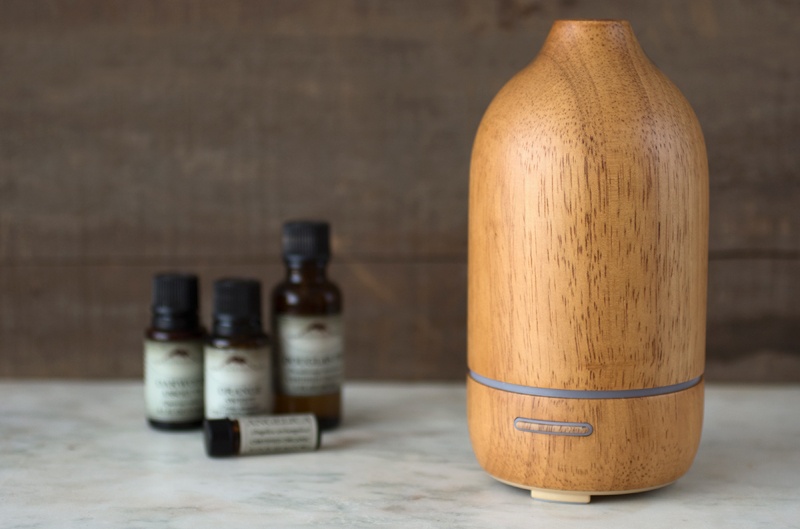 Natural wood ultrasonic diffuser with essential oils on counter