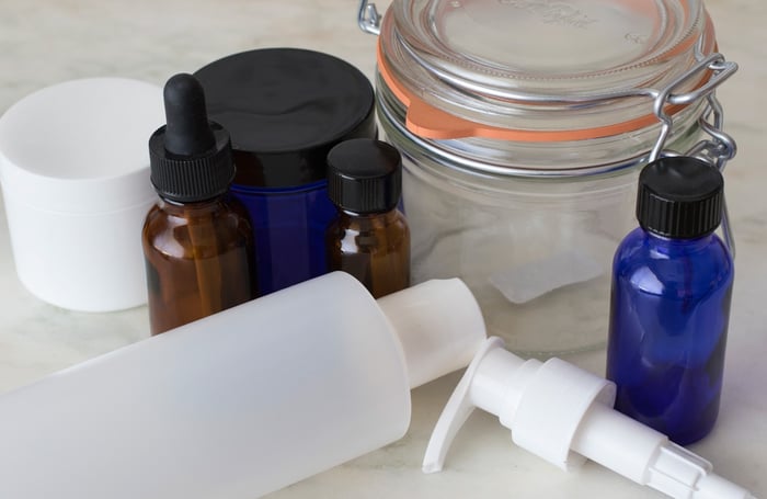 Empty white plastic and cobalt glass containers for DIY body care
