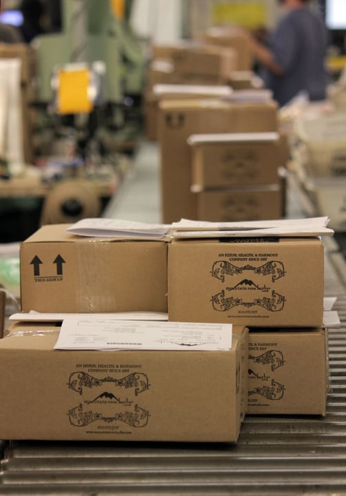 Shipping Boxes at Mountain Rose Herbs rolling down conveyor belt to be shipped out