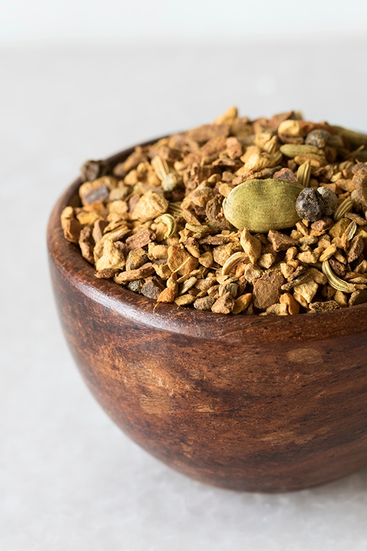Close up of turmeric chai tea blend in wooden bowl